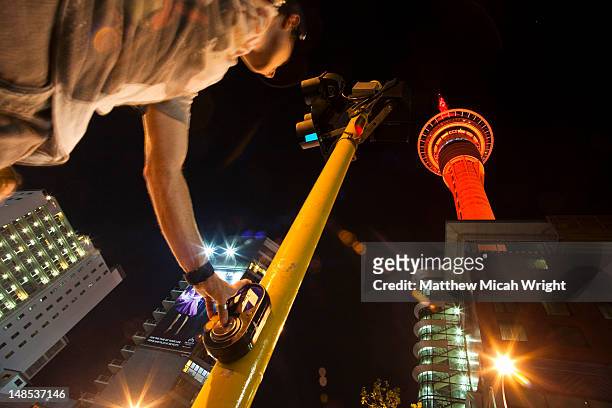 the glowing lights of the auckland sky tower at night - timelapse new zealand stock pictures, royalty-free photos & images