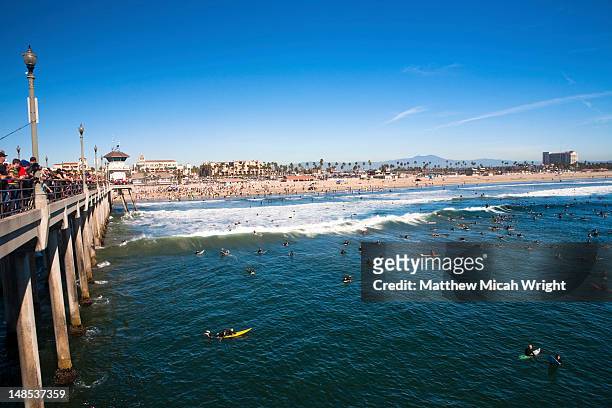 surfers at memorial paddle out commemorating pro surfer andy irons by huntington beach pier. - huntington beach stock pictures, royalty-free photos & images