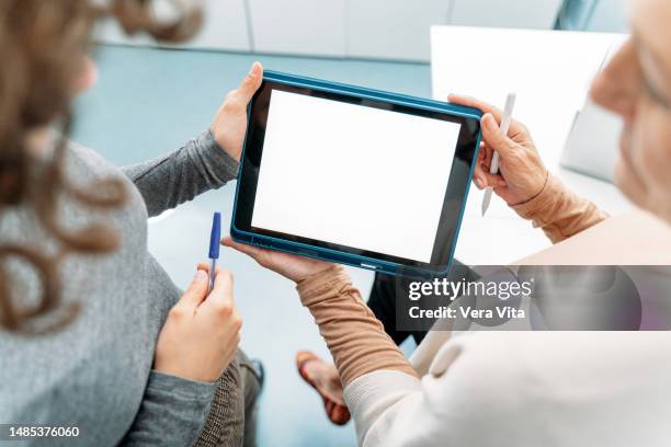 top view of unrecognizable business women hands working with white screen digital device - touchpad stock-fotos und bilder