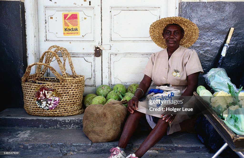 Woman with vegetables on roadside.