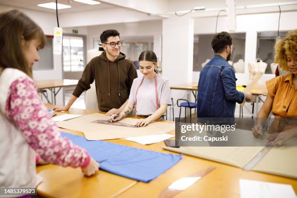 fashion students measuring  and cutting fabrics during class - sewing pattern stock pictures, royalty-free photos & images