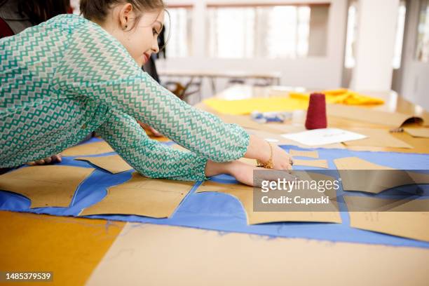 woman tracing clothing patterns on fabric - sewing pattern bildbanksfoton och bilder