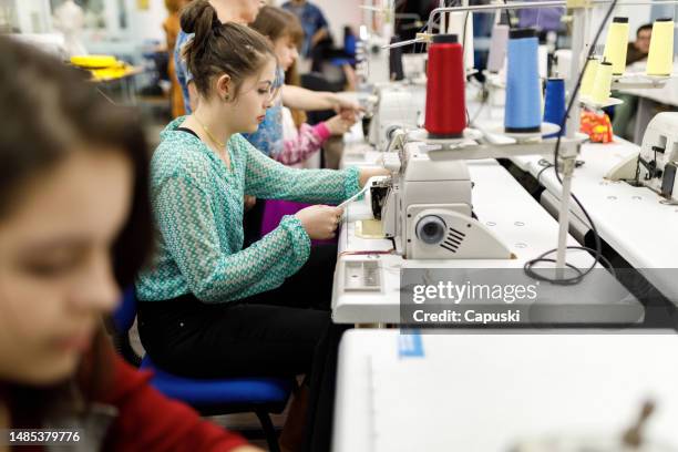 fashion students using sewing machines during class - sewing stock pictures, royalty-free photos & images