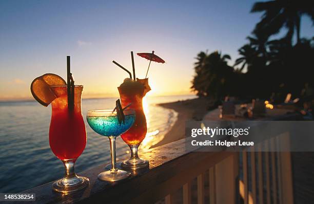 cocktails on balcony at sunset, rarotongan beach resort. - beach cocktail stock pictures, royalty-free photos & images