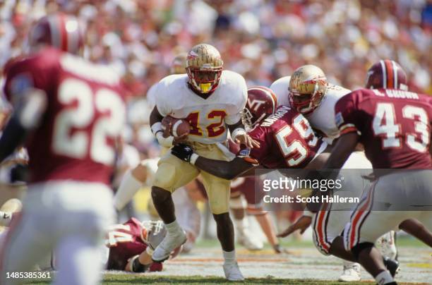 Amp Lee, Running Back of the Florida State Seminoles in motion running the football is tackled by James Hargrove, Defensive Linebacker for the...