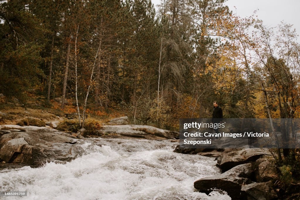 Young man exploring nature by a river in the Canadian Shield