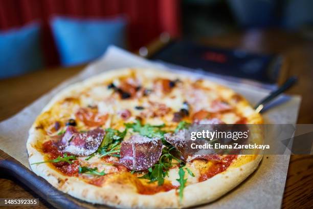 pizza on pan with slice lifted by spatula - parma ham stock pictures, royalty-free photos & images