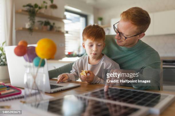 little boy doing homework with his father. - fuel and power generation stock-fotos und bilder