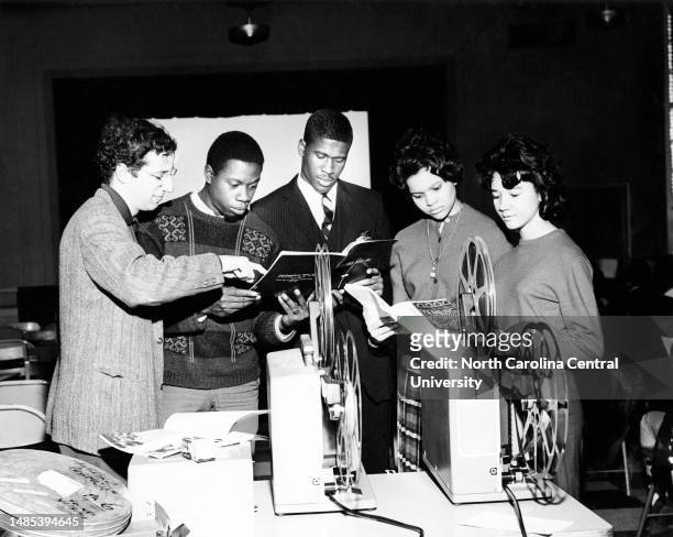 Members of North Carolina College's new Film Society check catalogs and materials prior to the showing of the organization's first film Saturday. The...