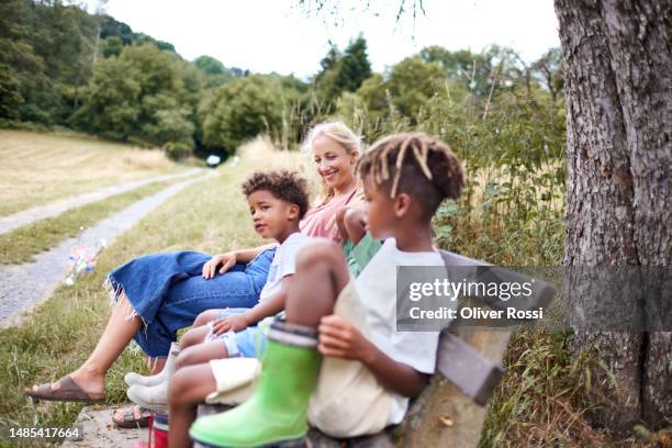 mother with children sitting on bench in rural landscape - mère célibataire photos et images de collection