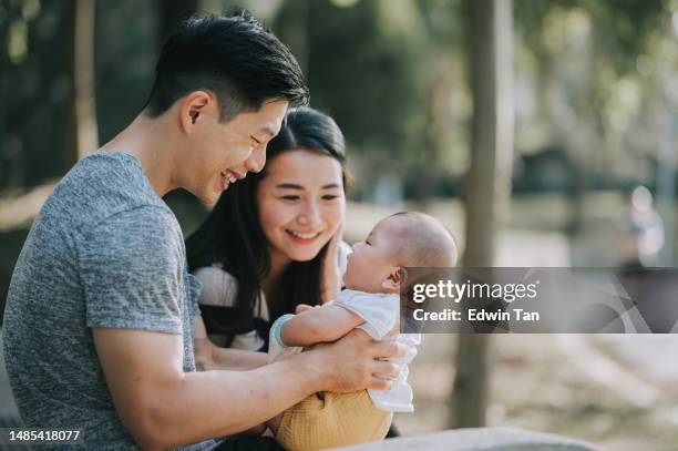 asiatisch-chinesische eltern, die sich am wochenendmorgen mit ihrem kleinen jungen im öffentlichen park verbinden - asian young family stock-fotos und bilder