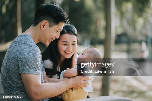 Asian Chinese Parents bonding with their baby boy in public park during weekend morning Asian Chinese Parents bonding with their baby boy in public park during weekend morning