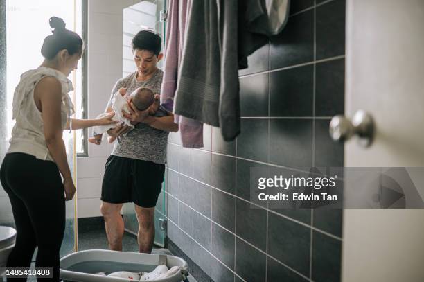 pais chineses asiáticos limpando o bebê secando com toalhas no banheiro depois de tomar banho - baby shower - fotografias e filmes do acervo