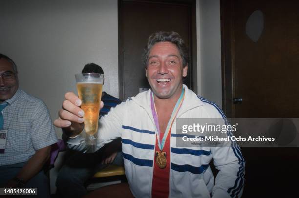 German weightlifter Rolf Milser enjoys a glass of beer following his gold-winning performance in the men's 100 kg competition of the men's...