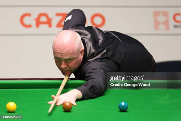 John Higgins of Scotland plays a shot during their Quarter Final match against Mark Selby of England on Day Twelve of the Cazoo World Snooker...