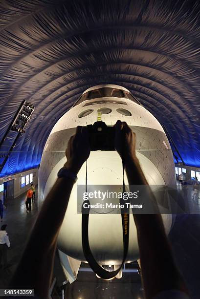 Person holds a camera at the Space Shuttle Enterprise during a press preview of the Intrepid Sea, Air & Space Museum’s new Space Shuttle Pavilion on...
