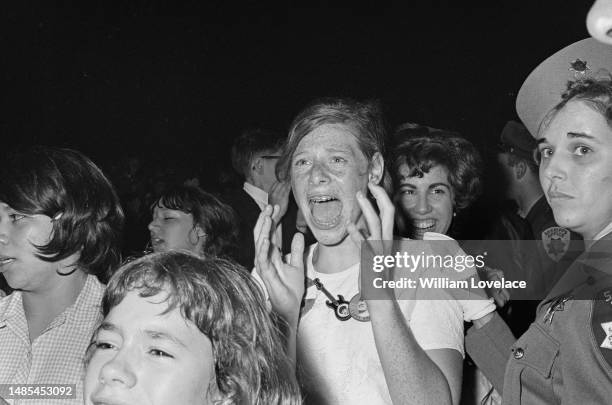 Fans and a police officer at a Beatles concert at the Cow Palace in Daly City, near San Francisco, California, during their Summer 1964 United States...