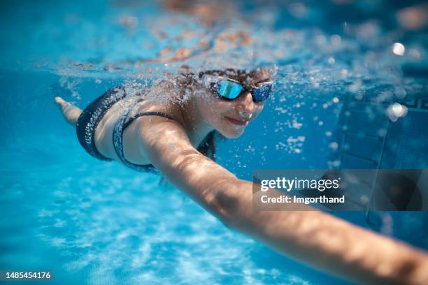 little girl swimming freestyle in a swimming pool - swimming stock pictures, royalty-free photos & images