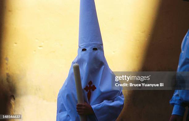 hermandad penitent holding long candle during holy week. - week 2012 stock pictures, royalty-free photos & images