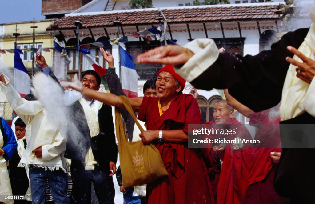 Members of Tibetan community throwing tsampa (barley flower) during Losar (Tibetan New Year) celebrations at Bodhnath Stupa.