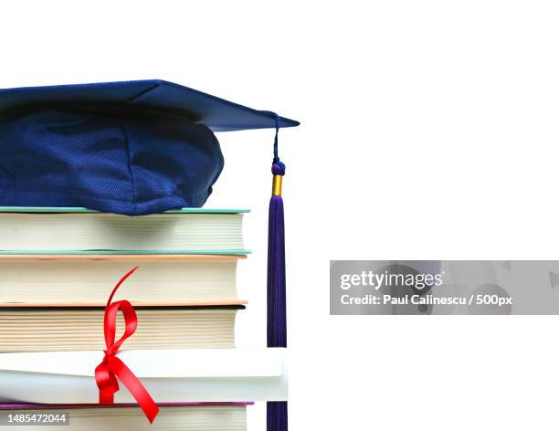 stack of books with cap and diploma on white,romania - degree stock pictures, royalty-free photos & images