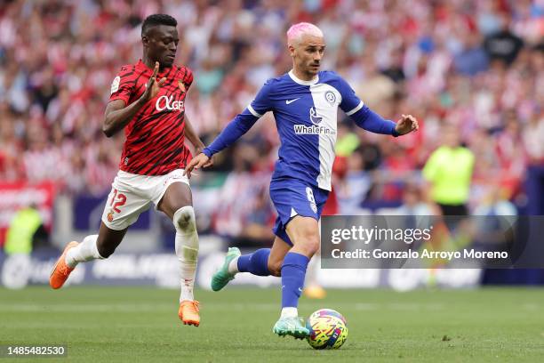 Antoine Griezmann of Atletico Madrid runs with the ball whilst under pressure from Iddrisu Baba of RCD Mallorca during the LaLiga Santander match...