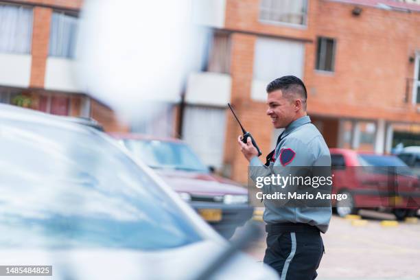 le gardien d’un immeuble prend note des voitures garées dans le parking - agent de sécurité photos et images de collection