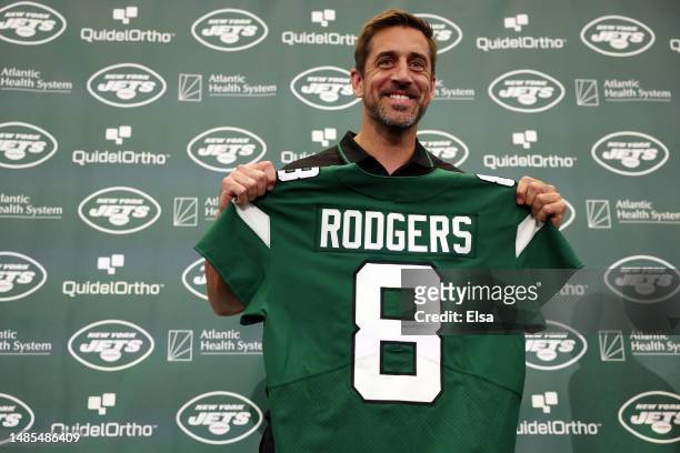 New York Jets quarterback Aaron Rodgers poses with a jersey during an introductory press conference at Atlantic Health Jets Training Center on April...
