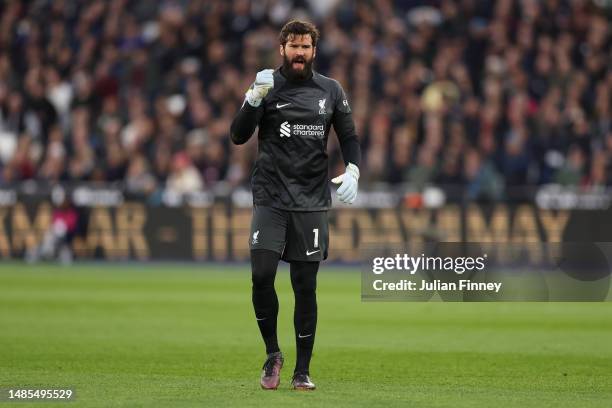 Alisson Becker of Liverpool celebrates after Cody Gakpo scores the team's first goal during the Premier League match between West Ham United and...