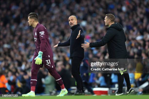 Pep Guardiola, Manager of Manchester City, interacts with Ederson during the Premier League match between Manchester City and Arsenal FC at Etihad...