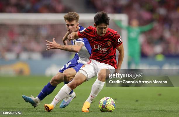 Lee Kang-In of RCD Mallorca controls the ball whilst under pressure from Pablo Barrios of Atletico Madrid during the LaLiga Santander match between...