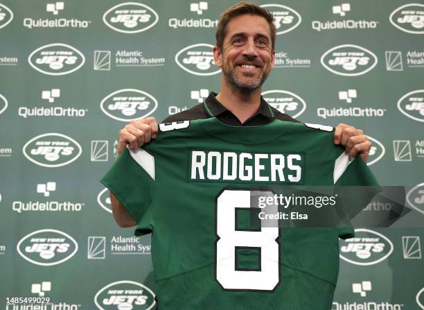 New York Jets quarterback Aaron Rodgers poses with a jersey during an introductory press conference at Atlantic Health Jets Training Center on April...