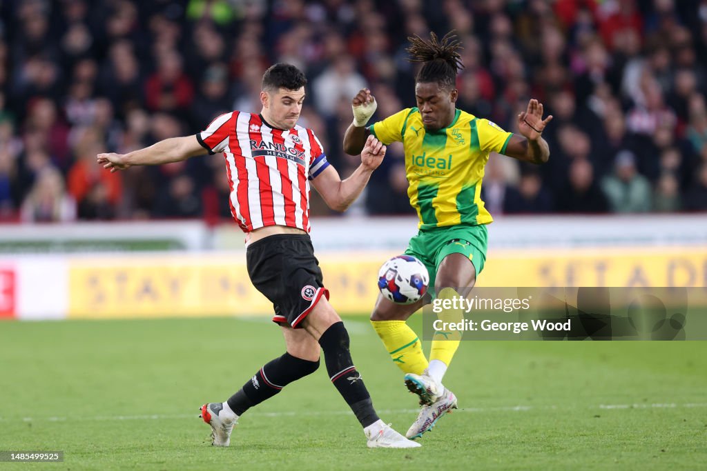 John Egan of Sheffield United battles for possession with Brandon
