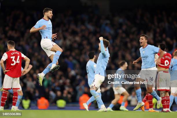 John Stones of Manchester City celebrates with alongside teammates Ruben Dias and Rodri after scoring the team's second goal following a VAR check...