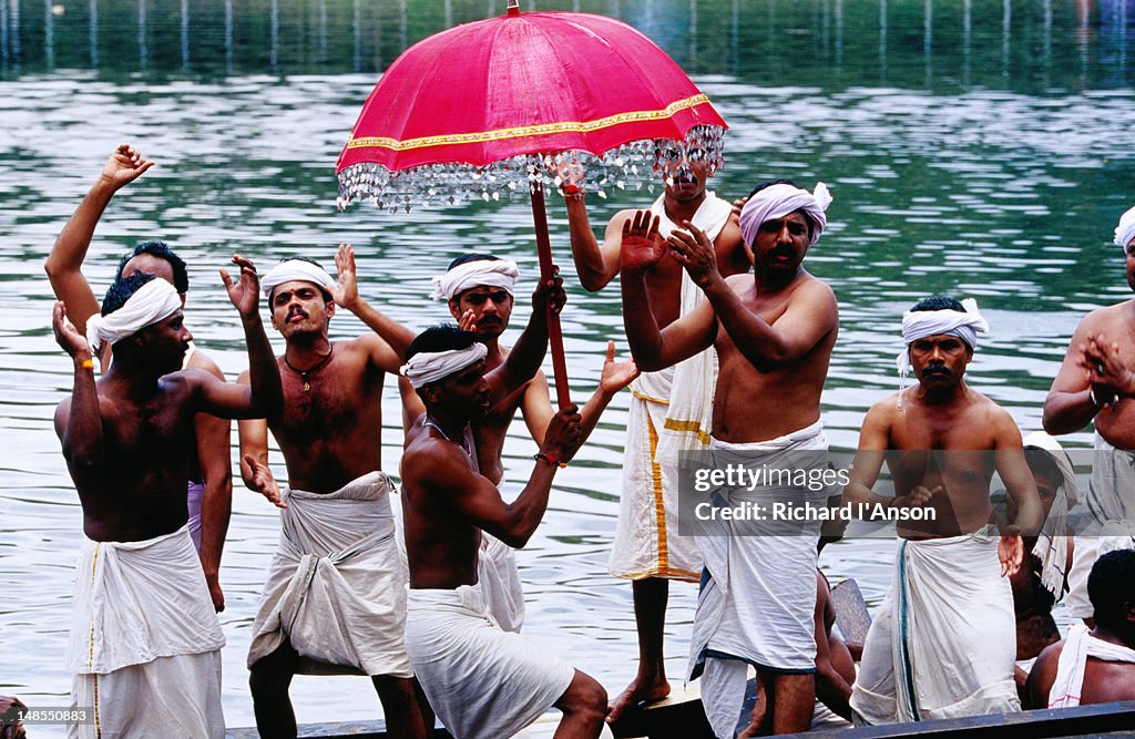 Snake boat crew singing and chanting during pre-race procession on Pampa River River during Onam festival celebrations.