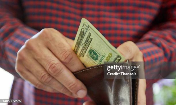 close up on man's hand holding twenty dollar bill, us currency, cash - spending money stockfoto's en -beelden