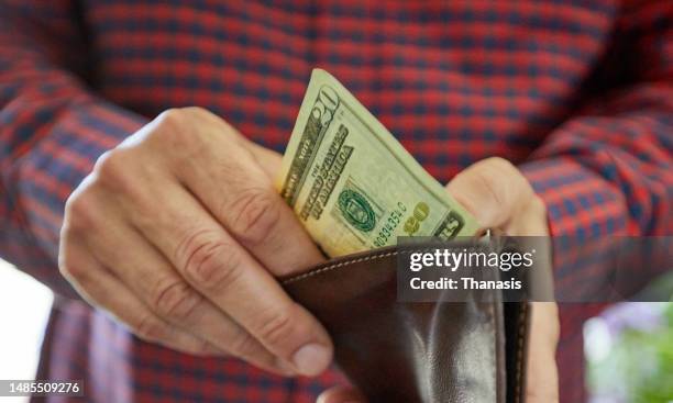 Close up on man"s hand holding twenty dollar bill, US currency, cash