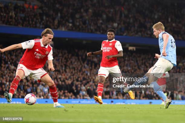 Kevin De Bruyne of Manchester City scores the team's third goal whilst under pressure from Rob Holding of Arsenal during the Premier League match...