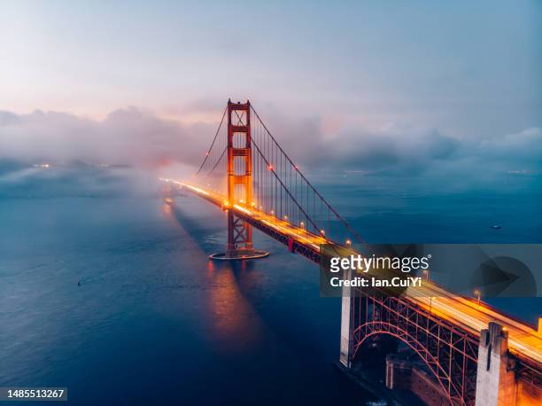 red golden gate bridge under a foggy sky (dusk) - golden gate bridge fotografías e imágenes de stock