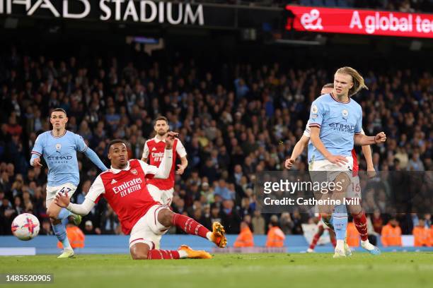 Erling Haaland of Manchester City scores the team's fourth goal past Gabriel of Arsenal during the Premier League match between Manchester City and...