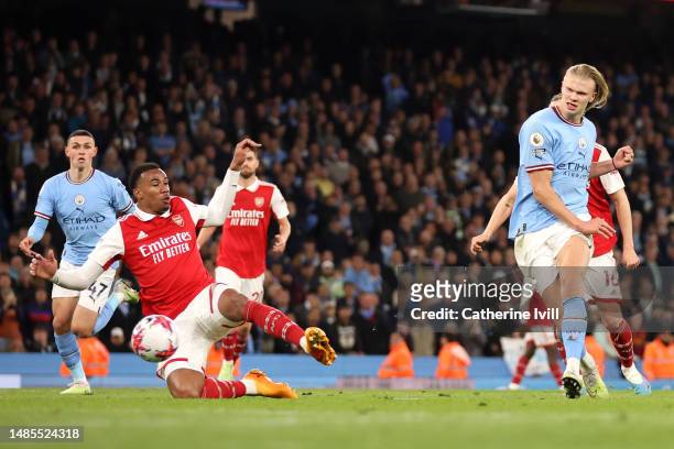 Erling Haaland of Manchester City scores the team's fourth goal past Gabriel of Arsenal during the Premier League match between Manchester City and...