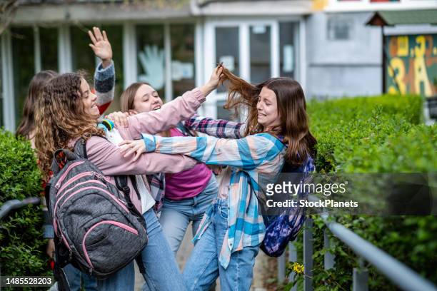 teenage girls fight in front of the school - children violence stock pictures, royalty-free photos & images