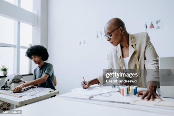 portrait of a fashion stylist designing a dress - atelier stock pictures, royalty-free photos & images