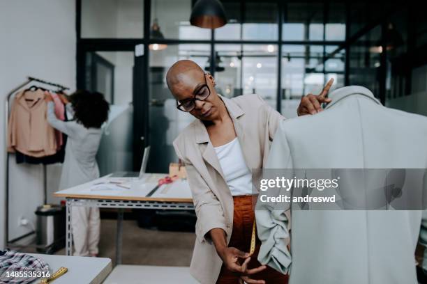 woman measuring clothes on mannequin at sewing workshop - atelier stock pictures, royalty-free photos & images