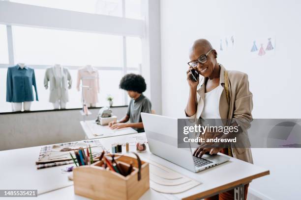 gerente de tienda de ropa hablando por teléfono inteligente - fashion director fotografías e imágenes de stock