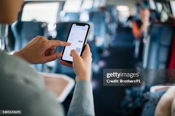woman traveler in train looking at electronic ticket on her phone screen - train ticket stock pictures, royalty-free photos & images