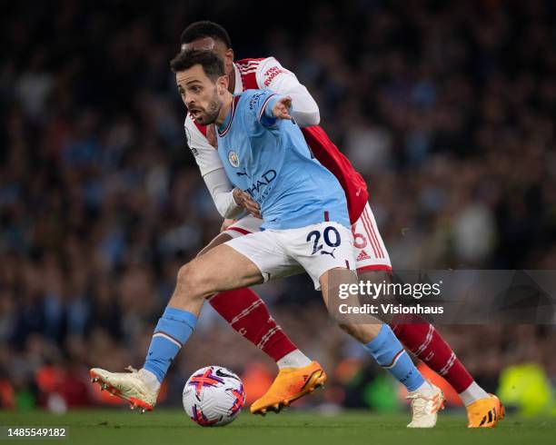 Bernardo Silva of Manchester City and Gabriel Magalhaes of Arsenal in action during the Premier League match between Manchester City and Arsenal FC...