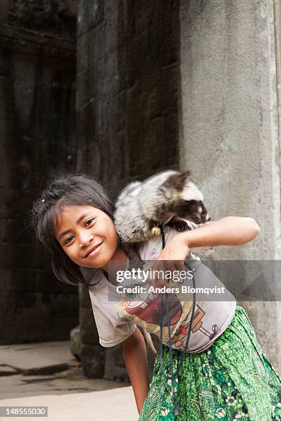 local girl with her pet palm civet at preah khan temple. - palm civet stock pictures, royalty-free photos & images