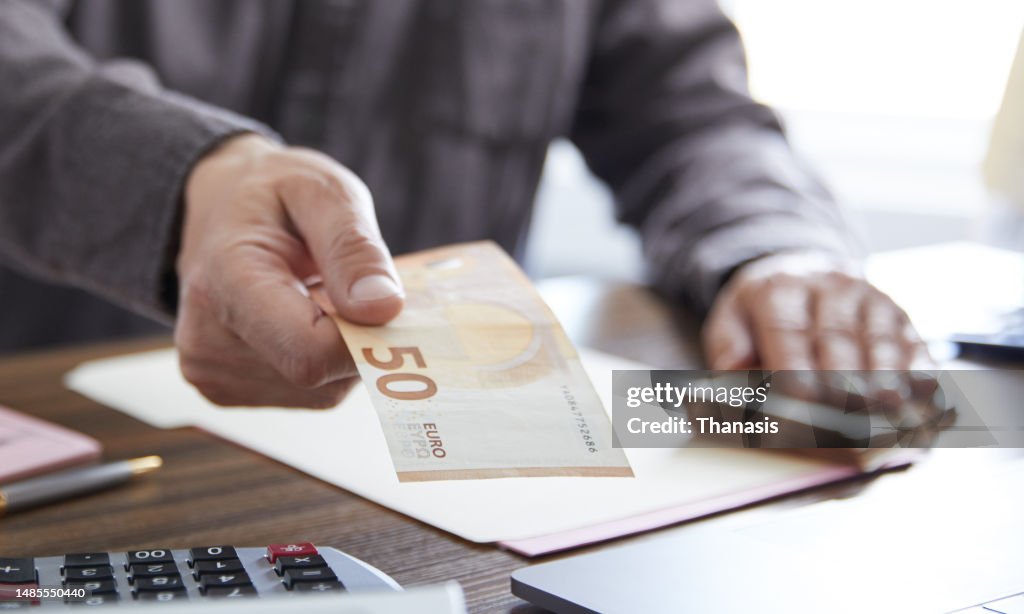Close up on man's hand handing over money, EU banknotes,