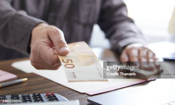 close up on man's hand handing over money, eu banknotes, - probe stock pictures, royalty-free photos & images